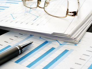 Business report with financial charts. Stack of papers in the office.
