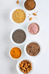 Healthy super food clean eating selection (seeds, powder turmeric, carob, nuts, dried beet)