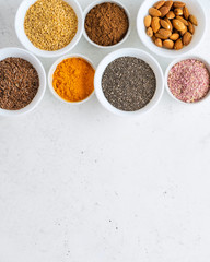 Healthy super food clean eating selection (seeds, powder turmeric, carob, nuts, dried beet)