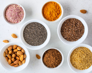 Healthy super food clean eating selection (seeds, powder turmeric, carob, nuts, dried beet)