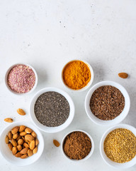 Healthy super food clean eating selection (seeds, powder turmeric, carob, nuts, dried beet)