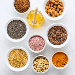 Healthy super food clean eating selection (seeds, powder turmeric, carob, nuts, honey, dried beet)