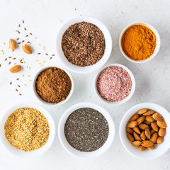 Healthy super food clean eating selection (seeds, powder turmeric, carob, nuts, dried beet)