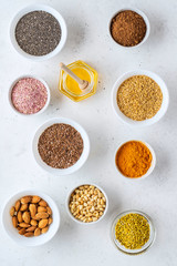 Healthy super food clean eating selection (seeds, powder turmeric, carob, nuts, honey, bee pollen, dried beet)