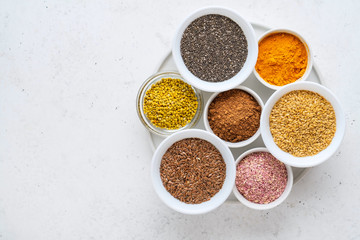 Healthy super food clean eating selection (seeds, powder turmeric, carob, bee pollen, dried beet)