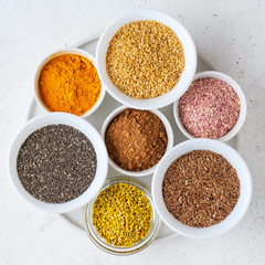 Healthy super food clean eating selection (seeds, powder turmeric, carob, bee pollen, dried beet)