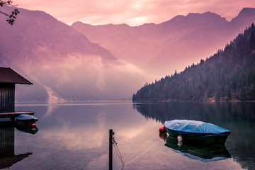 Small boat on lake Plansee in the European Alps, in Austria at early morning sunrise