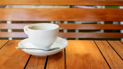 White cup of coffee on a wooden table.