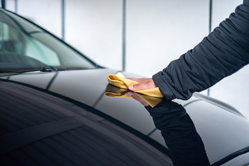 A person polishes the bonnet on his car