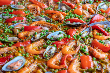 Spanish seafood paella in fry pan with mussels, shrimps and vegetables. Seafood paella background, closeup, traditional spanish rice dish