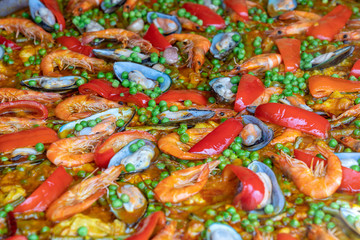 Spanish seafood paella in fry pan with mussels, shrimps and vegetables. Seafood paella background, closeup, traditional spanish rice dish