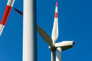 White and red wind turbines on a clear blue sky with copy space - Renewable energy concept