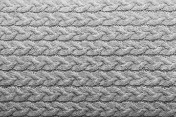 Light grey knit fabric background with horizontal cable pattern, wool texture in soft grey and white tones