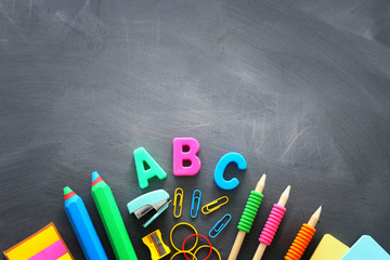 Back to school concept. stationery and books over classroom blackboard. top view, flat lay