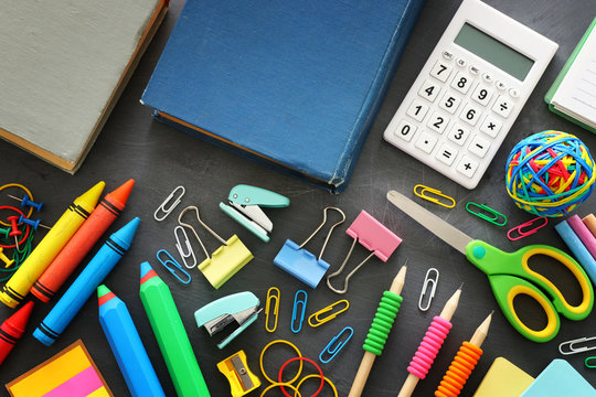 Back to school concept. stationery and books over classroom blackboard. top view, flat lay