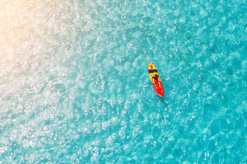 Man on a kayak in the sea with clear turquoise water. Kayaking, leisure activities on the ocean.
