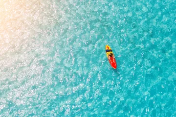 Mann auf einem Kajak im Meer mit klarem türkisfarbenem Wasser. Kajakfahren, Freizeitaktivitäten auf dem Ozean. © aapsky