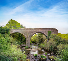 Fototapeta na wymiar Double-arch rubble stone railway bridge over Finglas river