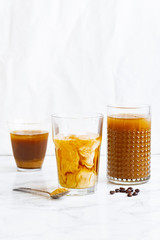 Iced coffee with cream and vanilla in various glasses on white background. Summer cocktail or dessert