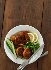 Plate of food. Fresh vegetarian cutlets with new potatoes and salad on a wooden table copy space top view