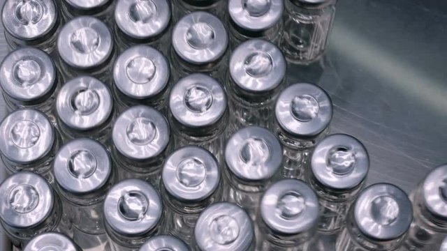 Pharmaceutical automatic production line - conveyor belt with empty glass bottles at pharmacy processing factory. Manufacturing, pharma industry, medicine, healthcare and automated technology concept