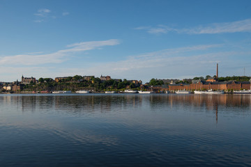 Fototapeta na wymiar Boats, pier and landmarks in Stockholm a tranquil morning, 