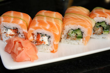 Sushi roll with salmon, avocado, philadelphia cheese on black background. Sushi menu. Japanese food.