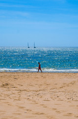 man walking alone on the beach in Portugal, Algarve coast