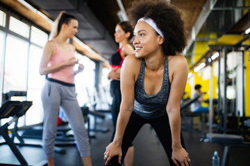 Fototapeta na wymiar Healthy young athletes doing exercises at fitness studio.