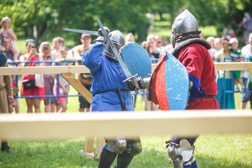 medieval jousting knight fight, in armor, helmets, chain mail with axes and swords on lists....