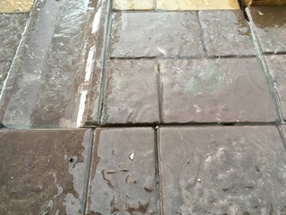 fragment of tiled courtyard, rain, water and splashes