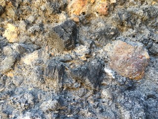 fragment of a dilapidated wall made of natural materials with stones, rural construction