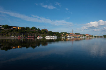 Fototapeta na wymiar Boats, pier and landmarks in Stockholm a tranquil morning, 