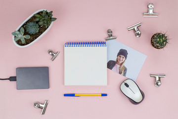 Open notebook, pen, mouse, succulents, photo, paper clips. Flat lay photo of a female workplace.