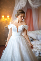 Fototapeta na wymiar Beautiful bride in white dress in hotel room