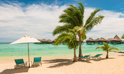 Beautiful French Polynesian beach with chairs and umbrella. Relaxation and vacation concept.