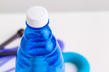 sport, healthy lifestyle and objects concept - close up of dumbbells, water bottle