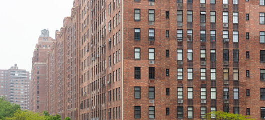Fototapeta premium New York, Manhattan Chelsea area. Brick wall facade skyscrapers against cloudy sky background