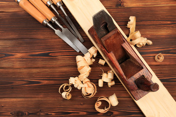 chisels plane and sawdust on a wooden table.