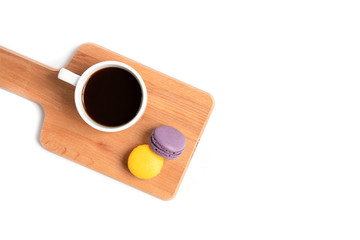 macaroons and a cup of coffee on wooden board