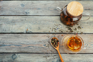 Cup of tea and tea leaves on wooden table