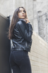 Beautiful young woman adjusting her leather collar jacket