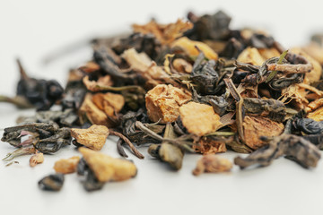 Dried tea leaves close up on white background