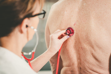 Doctor using stethoscope to exam patient