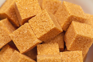 Brown cane sugar cubes isolated on white background