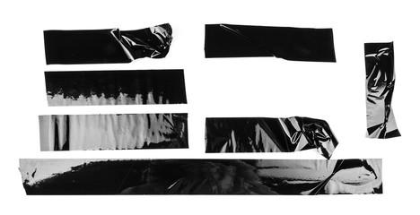 Torn different size black sticky tape, adhesive pieces