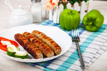 Kupaty in a white plate and vegetables