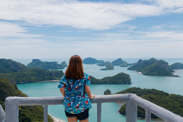 Fototapeta na wymiar Young asian woman traveler with backpack looking view at view point at Moo Koh Angthong, Thailand.