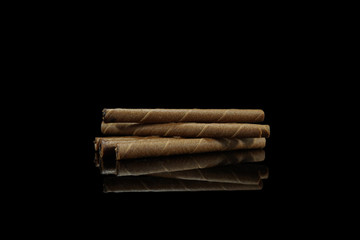 Biscuit snack roll isolated on black background with reflection