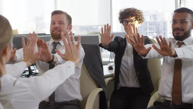 Tracking right of several diverse office workers doing exercises in office